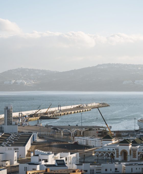 Uitzicht op de haven van Tangier in Marokko, met de zee en heuvelachtige achtergrond.