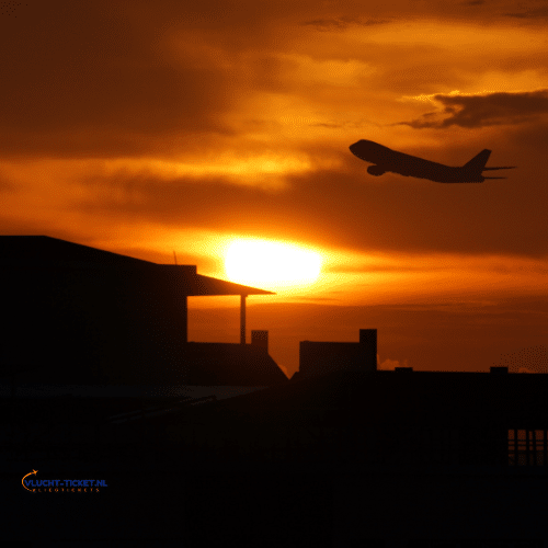 Vliegtuig dat opstijgt bij zonsondergang voor een last minute vlucht.