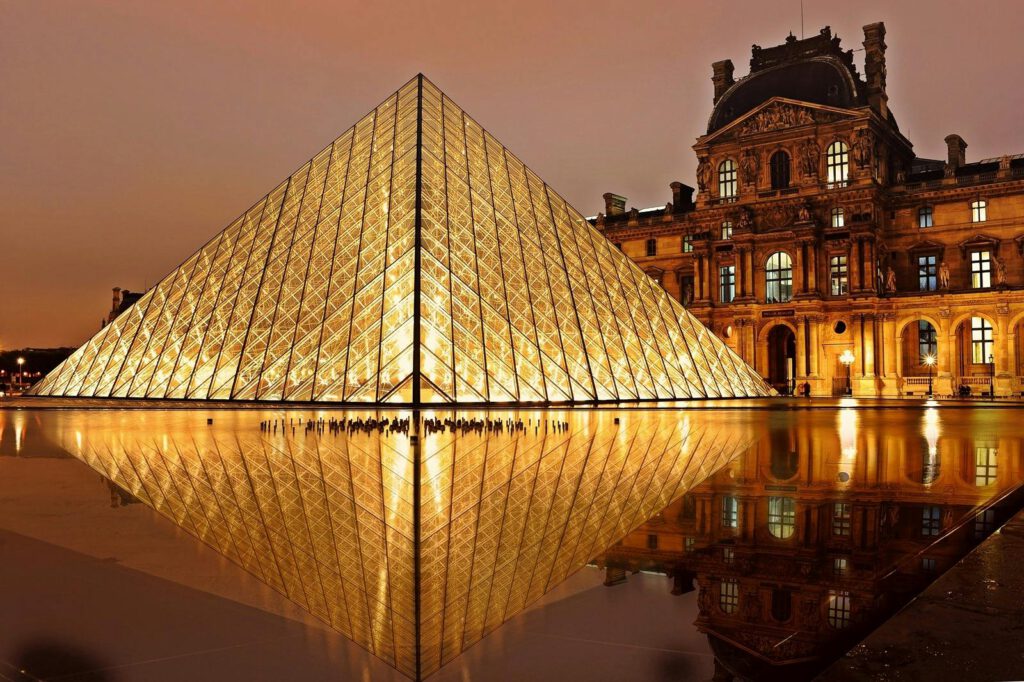 Verlichte glazen piramide van het Louvre in Parijs bij nacht