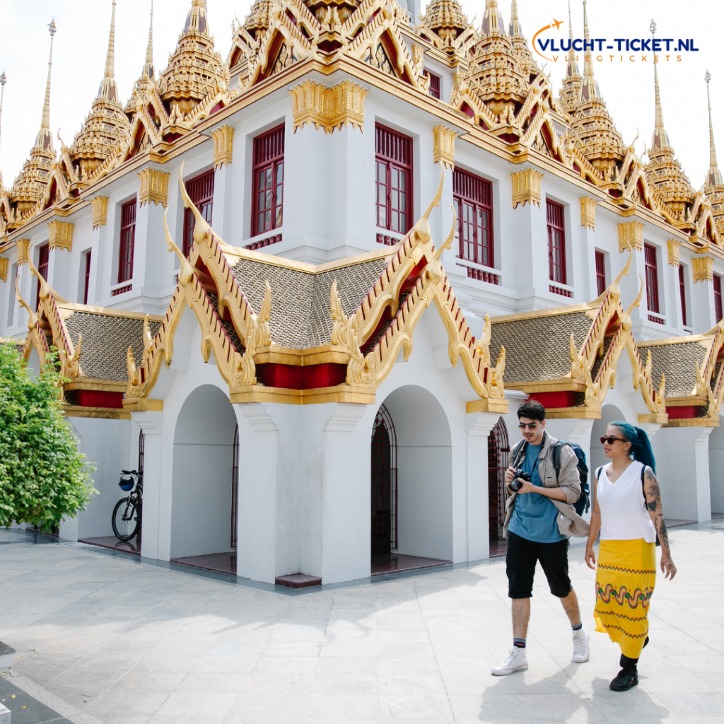 Twee toeristen wandelen bij een tempel in Bangkok tijdens een last minute vakantie naar Thailand