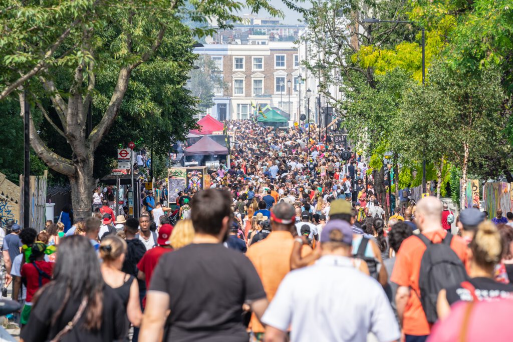 Mensenmassa tijdens het Notting Hill Carnival in Londen, een unieke ervaring bereikbaar met goedkope vluchten vanuit Amsterdam.