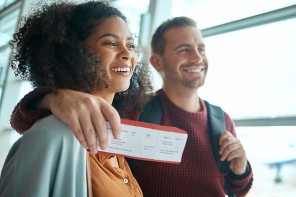 Gelukkig stel met een vliegticket in de hand op de luchthaven.